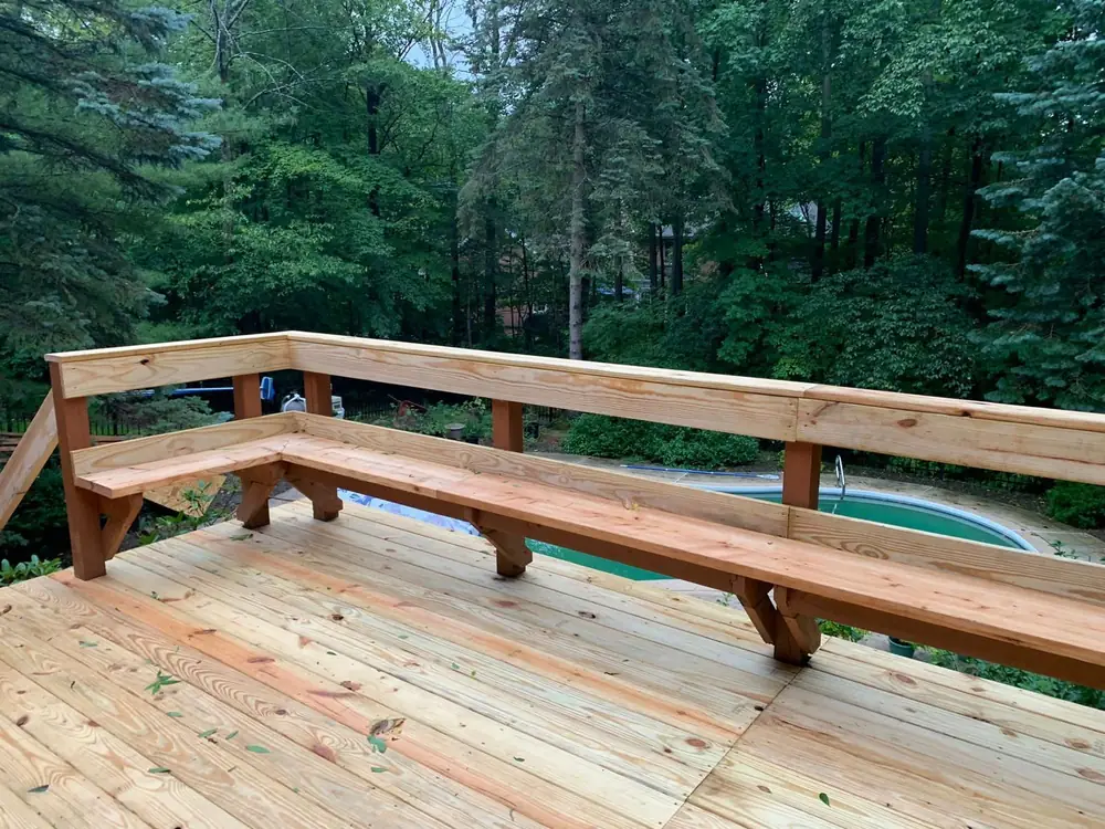 Cedar deck with built in bench seating beside a pool in Buffalo NY