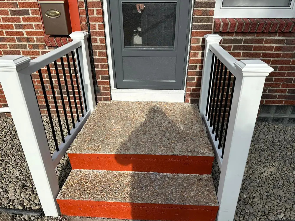Rebuilt front porch steps with black railing in Buffalo NY