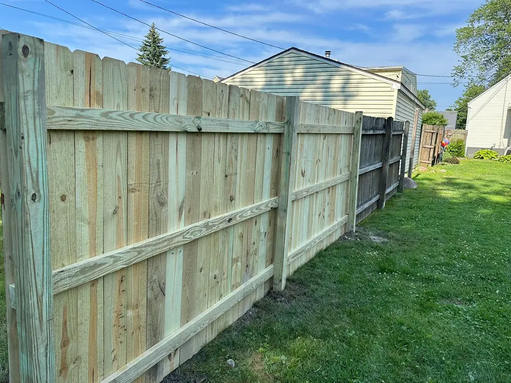 New wood privacy fence run along a back property line in Buffalo NY