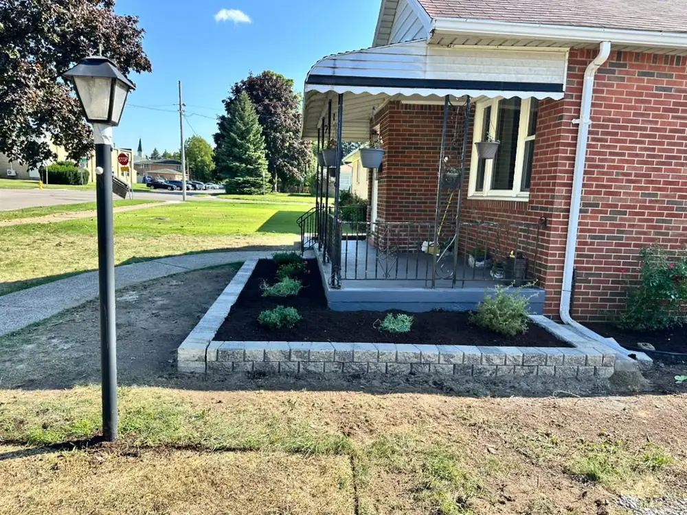 Stone retaining wall and raised planting bed built at a Buffalo NY home